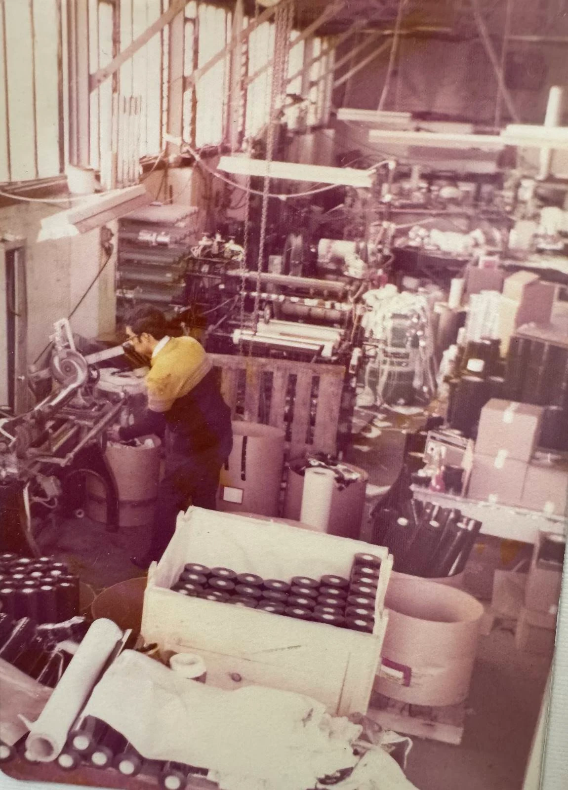 Early PPC factory floor with an operator working among coating and converting equipment