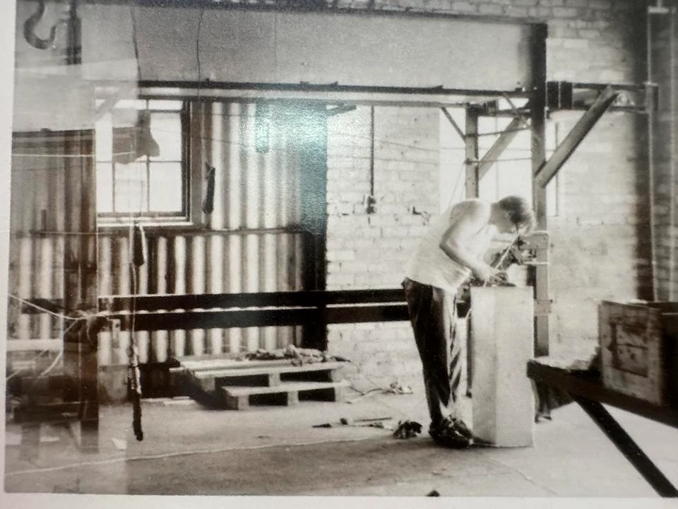 Worker inspecting equipment in an early PPC manufacturing facility